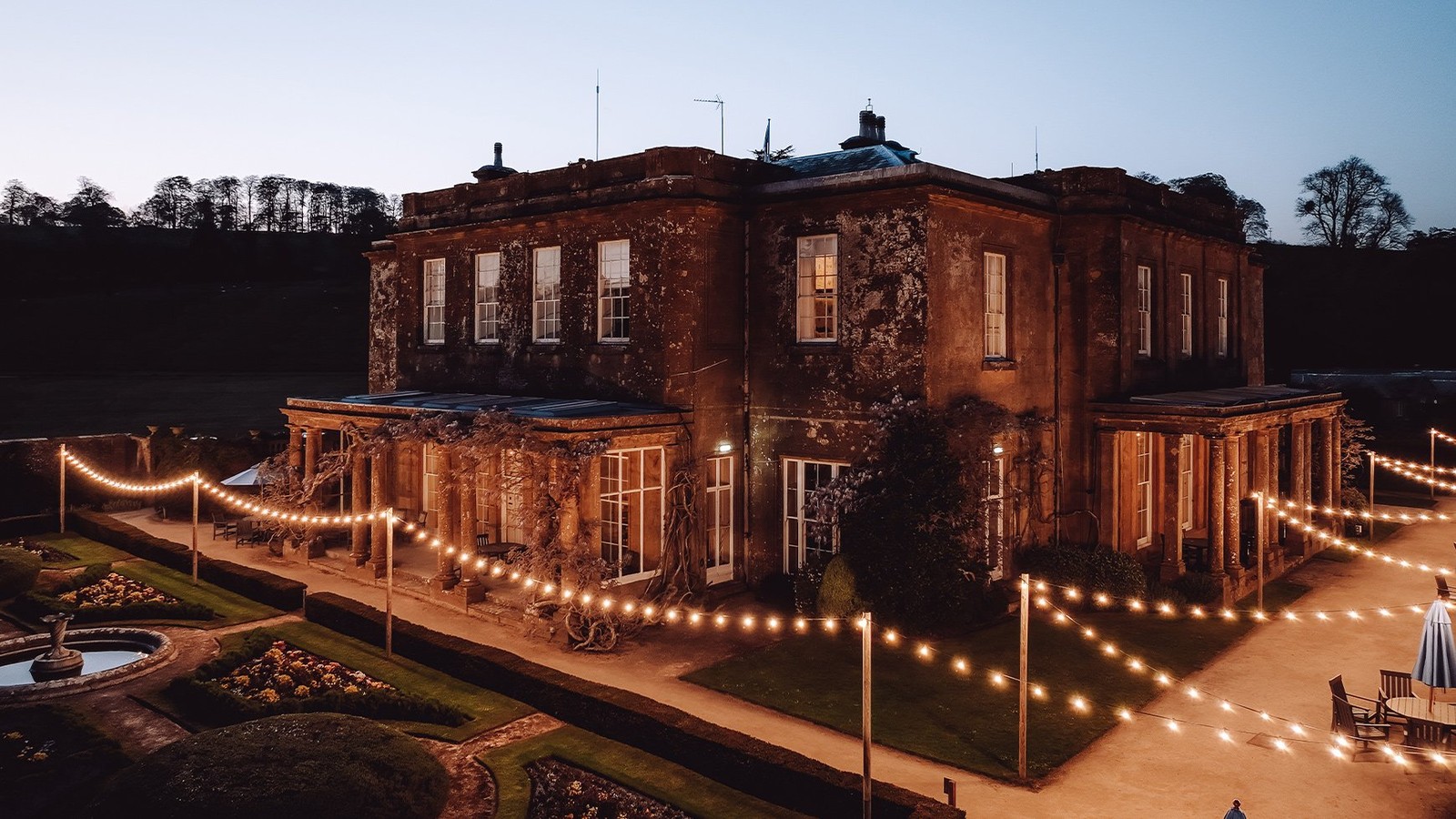 As evening falls, fairy lights twinkle across the terrace and gardens of Cricket House, casting a warm glow that feels nothing short of magical.
