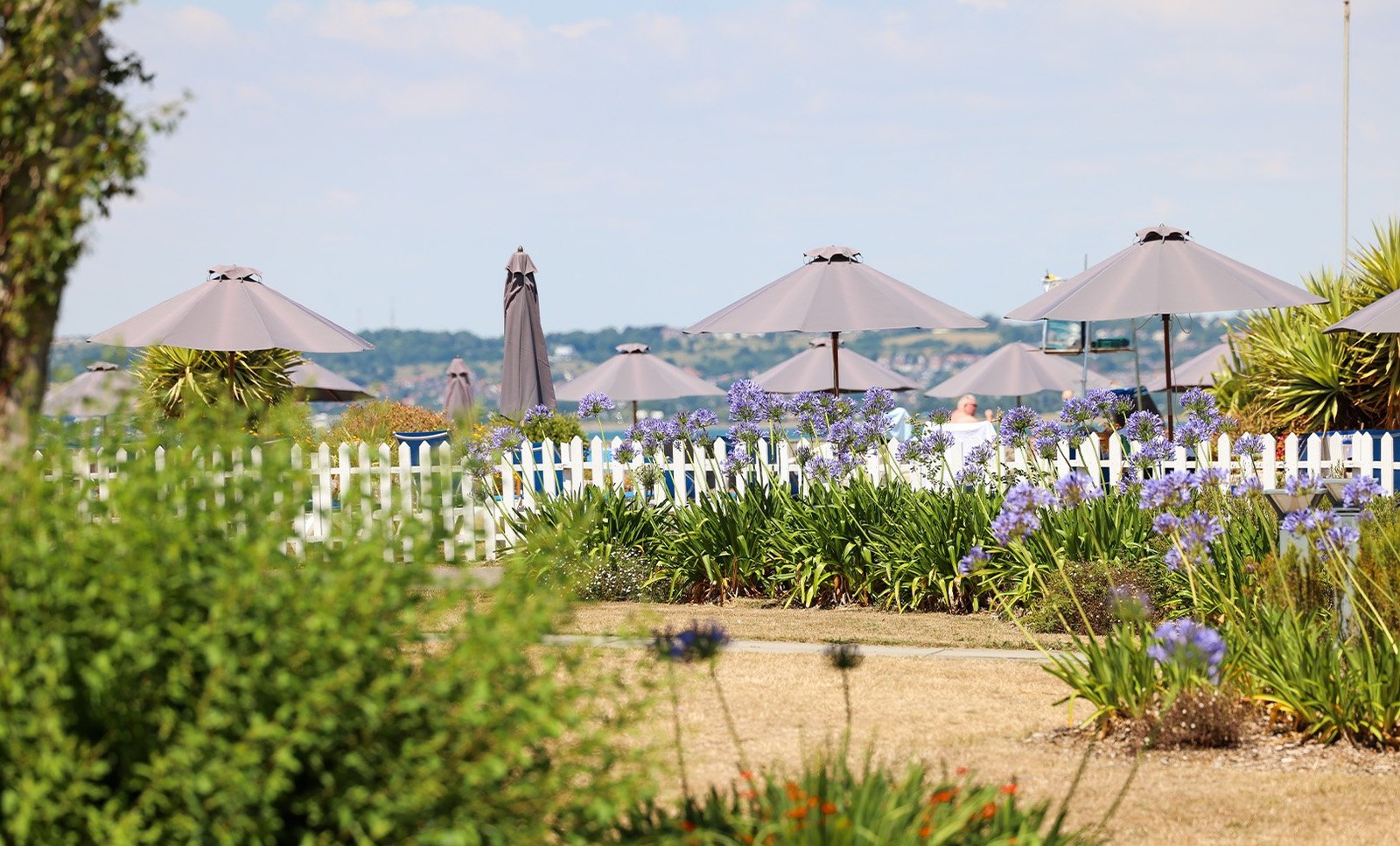 Vibrant gardens bursting with colourful flowers surround the outdoor pool, adding to the already picturesque views.