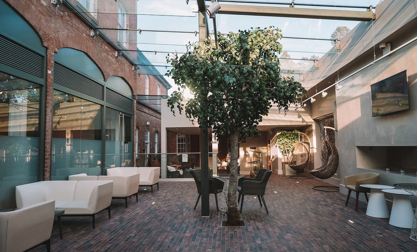 Welcome to tranquillity. The Spa reception at Studley Castle features a serene courtyard with a beautiful tree, perfect for unwinding before your pampering session.