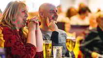 A couple enjoying a drink at a table at the BBC History Magazine Weekend at a Warner Hotel.