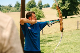 Warner team member teaching archery