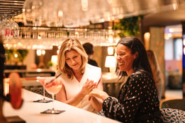 Guests enjoying cocktails at a hotel bar.
