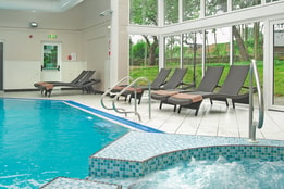 The spa at Bodelwyddan Castle, featuring a pool, bubble pool and loungers.