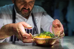 A chef at Studley Castle putting the finishing touches on a freshly prepared dish