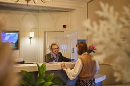 Sinah Warren reception with a team member helping a guest