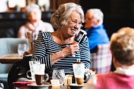 A hotel guest laughing at a table with others during a BBC History Magazine weekend event.