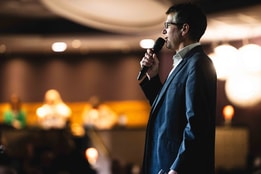 Speaker in suit giving a talk at BBC History Magazine Weekends at one of the Warner Hotels.