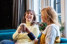 Two guests enjoying a hot drink together at Christmas time