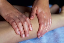 Close up of a person's leg as they receive a massage