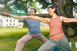 Mick and Angie smile as they try yoga outside Heythrop Park, a Warner Hotel