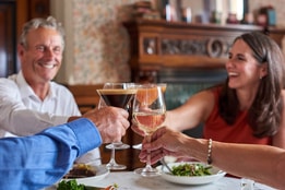 Guests making a toast over a delicious meal that they share in the Brasserie32 at Thoresby Hall Hotel