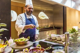 A chef smiling as he cooks up fresh omelettes at the buffet