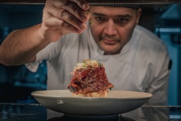 A chef putting the finishing touches on a dish