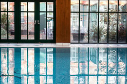 Indoor swimming pool with floor-to-ceiling windows, natural light and tranquil leisure facilities.