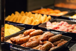 Hot breakfast buffet with sausages, bacon and hash browns