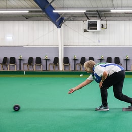 A woman playing short mat bowls