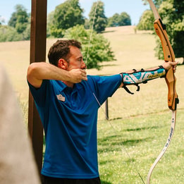 Warner team member teaching archery