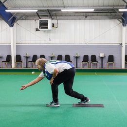 A woman playing short mat bowls