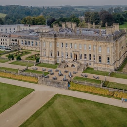 Aerial view of Heythrop Park showcasing its grand mansion and expansive, beautifully landscaped grounds.