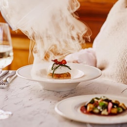 Close up of a steaming dish of smoked haddock fishcake