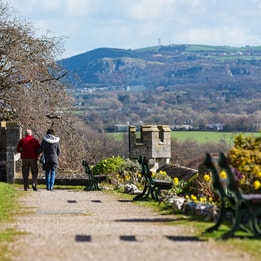 Guests walking through the grounds at Bodelwyddan Castle, with stunning views over the Clwydian Hills