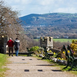 Guests enjoying scenic countryside views from landscaped hotel grounds and walking paths.