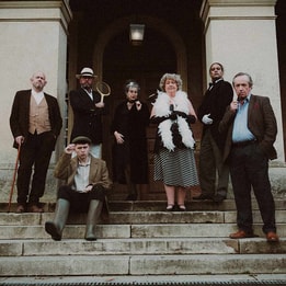 set of actors for the murder mystery break on stairs