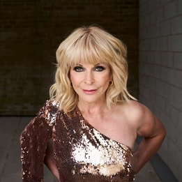 Toyah standing in front of brick wall