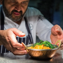 A chef at Studley Castle putting the finishing touches on a freshly prepared dish