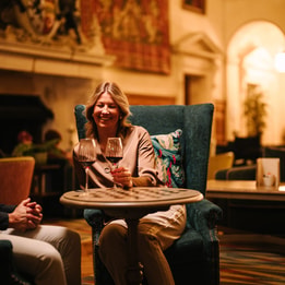 Guests enjoying wine in a historic hotel lounge.