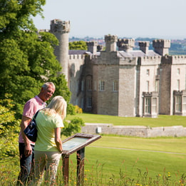 Guests at Bodelwyddan Castle exploring the grounds, with the castle in the background