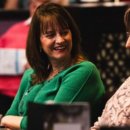 Two women at a table, smiling and enjoying each other's company during a BBC History Magazine weekend event.