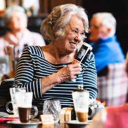 A hotel guest laughing at a table with others during a BBC History Magazine weekend event.