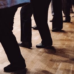 A group of people's legs as they dance in a line