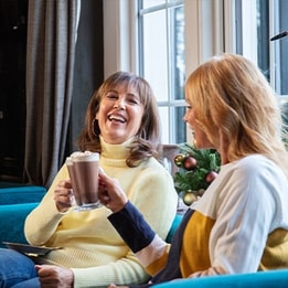 Two guests enjoying a hot drink together at Christmas time