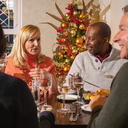 Four guests enjoying a meal together at christmas
