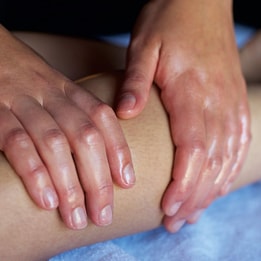 Close up of a person's leg as they receive a massage
