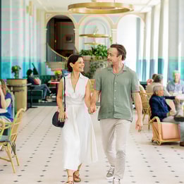 Mick and Angie walking towards the camera through the Orangery at Heythrop Park, a Warner Hotel