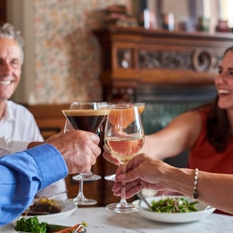 Guests making a toast over a delicious meal that they share in the Brasserie32 at Thoresby Hall Hotel