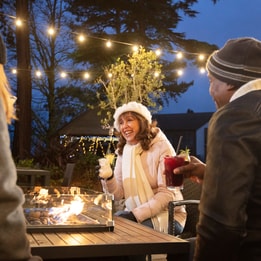 A group of friends enjoying a drink together around the firepit