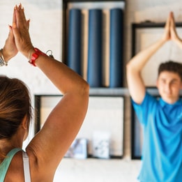 A guest holds a yoga pose as she copies the instructor inside the studio found in the Stables Spa at Studley Castle Hotel