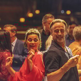 A man and woman joyfully dancing together at a lively party in Heythrop Park, capturing the spirit of celebration