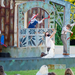 Outdoor theatre performance of A Midsummer Night’s Dream on a garden stage.