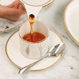 Tea being poured into a fine china cup