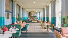 The orangery - a long bright corridor with large windows and brightly colour furniture