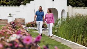Couple walking on a sunny day through the walled garden.