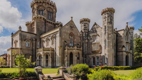 Studley Castle's exterior showcases a grand castle with a tall tower against the sky.