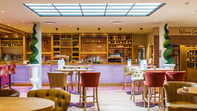 A view of the Evesham bar at Studley Castle featuring a bar and tables for dining.