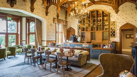 The oak room dining area in Studley Castle Hotel, showcasing classic architecture and refined furnishings.