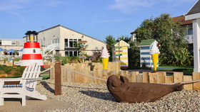 Brightly coloured decor on the grounds at Corton, including a lighthouse, some miniature beach huts, two XL ice cream cones and a wood carved seal